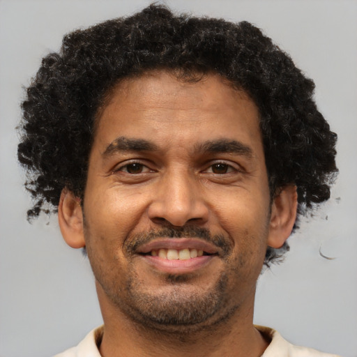 Joyful black adult male with short  brown hair and brown eyes