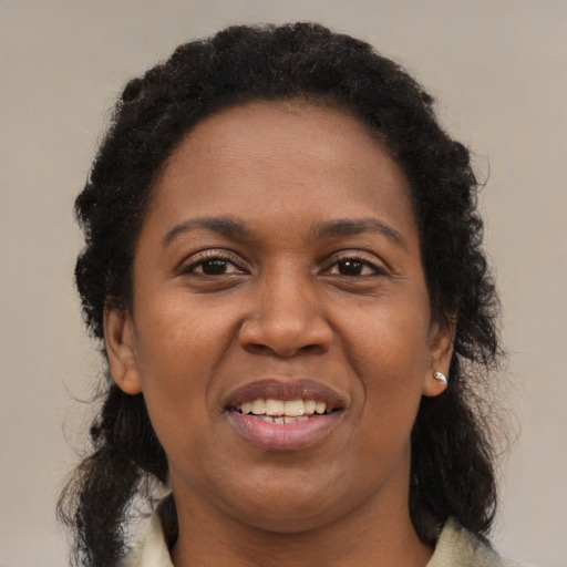 Joyful black young-adult female with medium  brown hair and brown eyes
