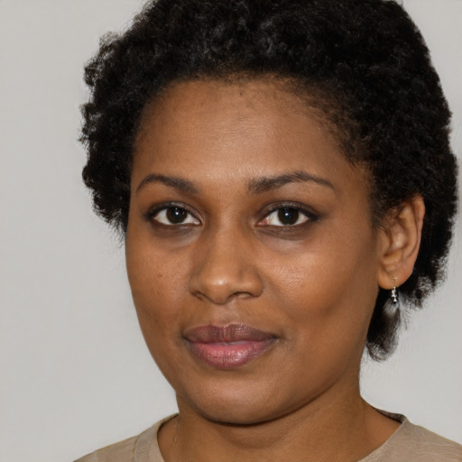 Joyful black young-adult female with short  black hair and brown eyes