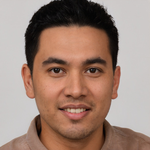 Joyful latino young-adult male with short  brown hair and brown eyes