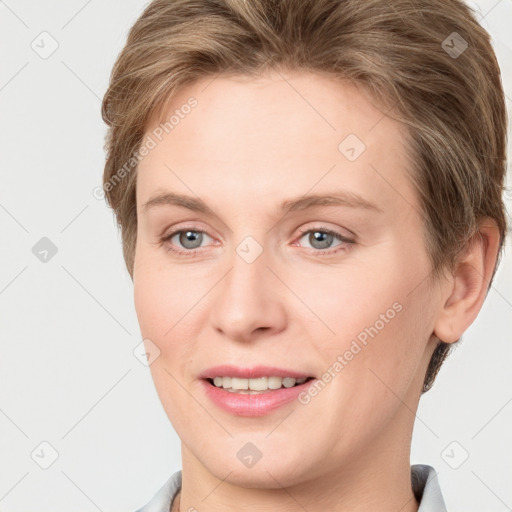 Joyful white young-adult female with short  brown hair and grey eyes