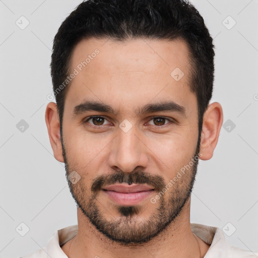 Joyful white young-adult male with short  black hair and brown eyes