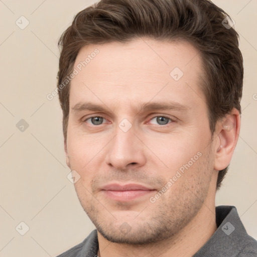 Joyful white young-adult male with short  brown hair and grey eyes