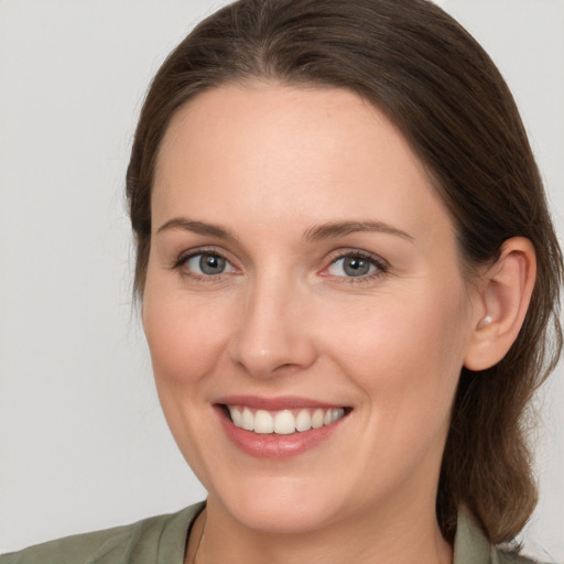 Joyful white young-adult female with medium  brown hair and grey eyes