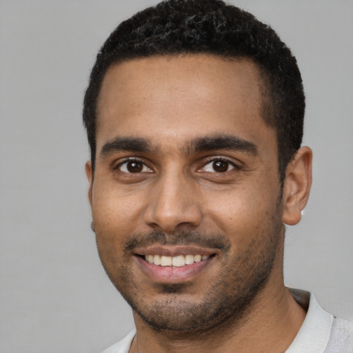 Joyful black young-adult male with short  black hair and brown eyes