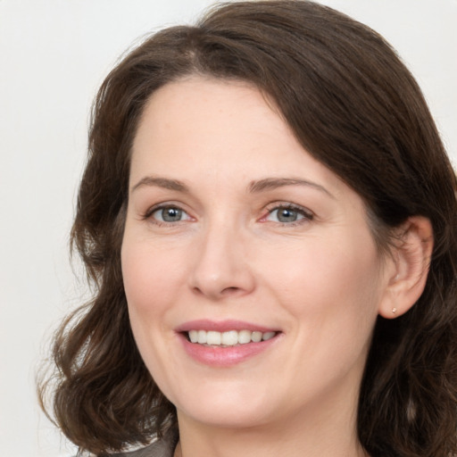 Joyful white young-adult female with medium  brown hair and grey eyes