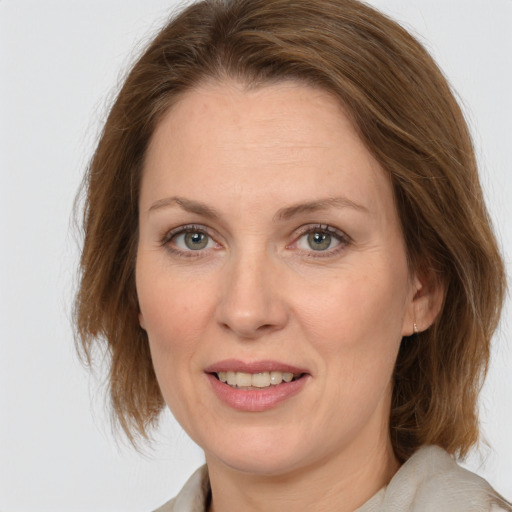 Joyful white adult female with medium  brown hair and blue eyes