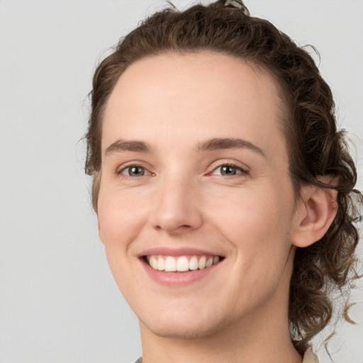 Joyful white young-adult female with medium  brown hair and green eyes