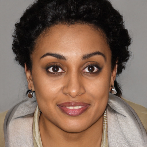 Joyful black young-adult female with short  brown hair and brown eyes