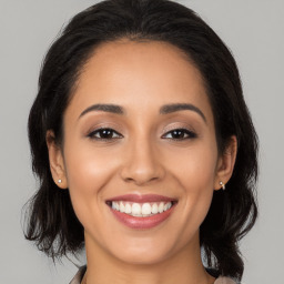 Joyful latino young-adult female with long  brown hair and brown eyes