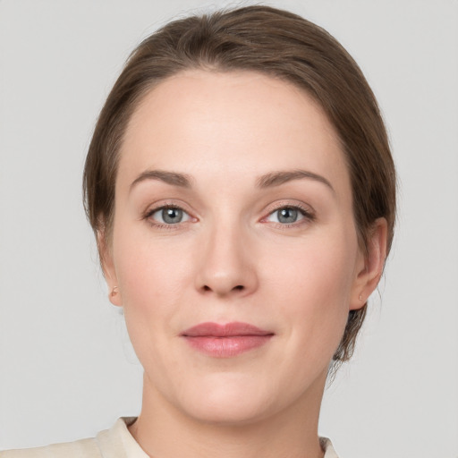 Joyful white young-adult female with medium  brown hair and grey eyes