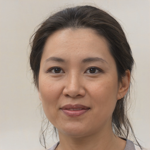 Joyful asian adult female with medium  brown hair and brown eyes