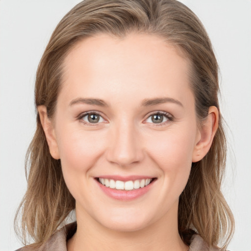 Joyful white young-adult female with long  brown hair and blue eyes