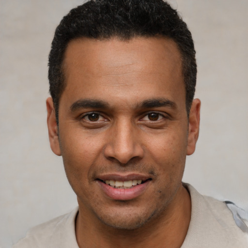 Joyful latino young-adult male with short  black hair and brown eyes