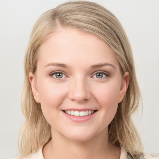 Joyful white young-adult female with medium  brown hair and blue eyes