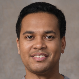 Joyful latino young-adult male with short  black hair and brown eyes