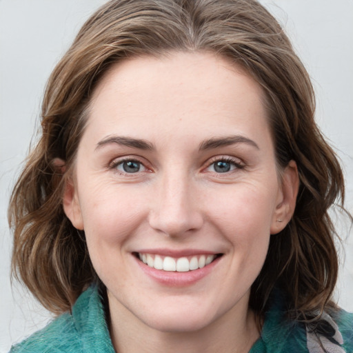 Joyful white young-adult female with medium  brown hair and blue eyes