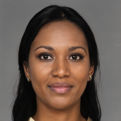 Joyful black young-adult female with long  black hair and brown eyes