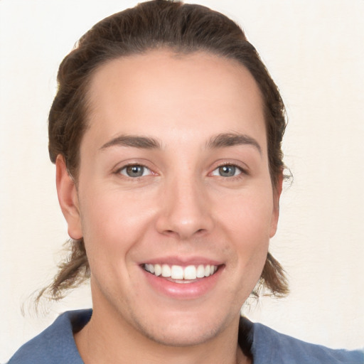 Joyful white young-adult female with medium  brown hair and grey eyes