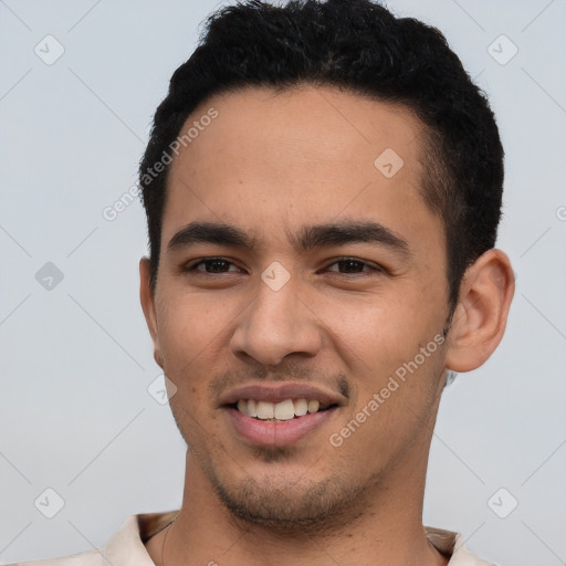 Joyful latino young-adult male with short  black hair and brown eyes