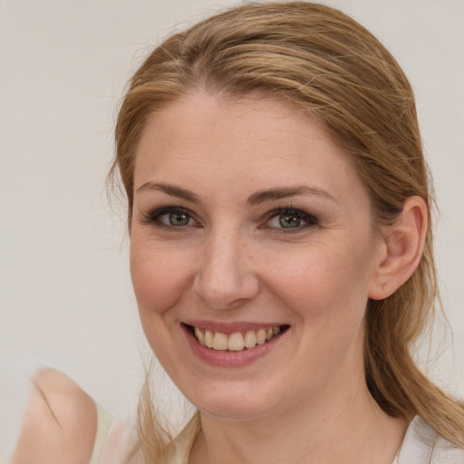 Joyful white young-adult female with medium  brown hair and blue eyes