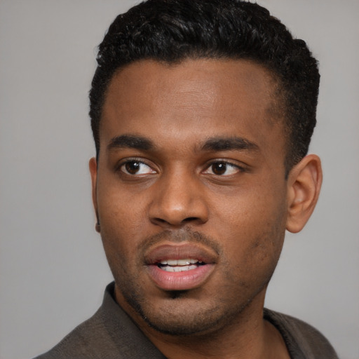 Joyful black young-adult male with short  black hair and brown eyes
