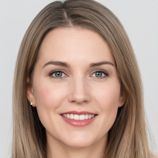 Joyful white young-adult female with long  brown hair and grey eyes