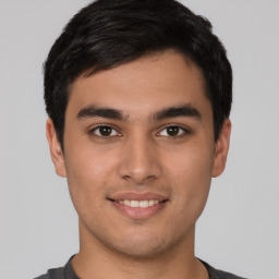 Joyful latino young-adult male with short  brown hair and brown eyes