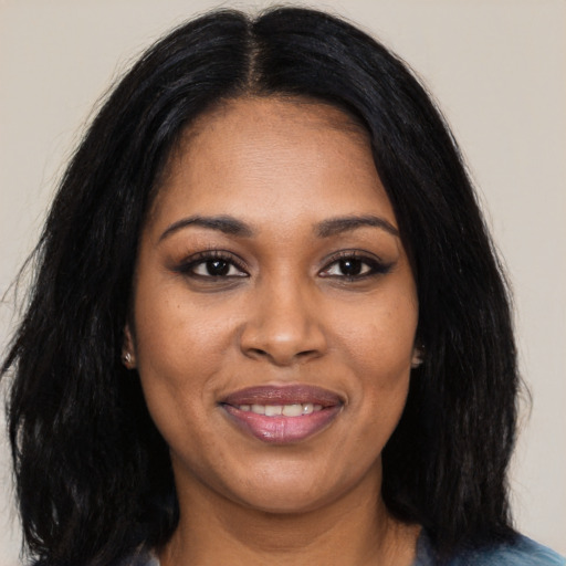 Joyful black young-adult female with long  black hair and brown eyes