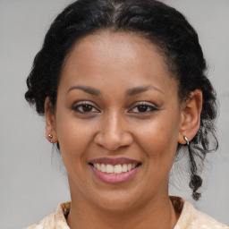 Joyful black adult female with medium  brown hair and brown eyes