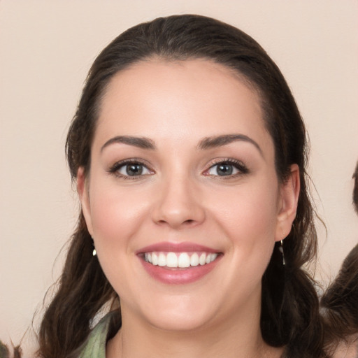 Joyful white young-adult female with long  brown hair and brown eyes