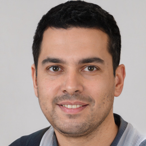 Joyful white young-adult male with short  black hair and brown eyes