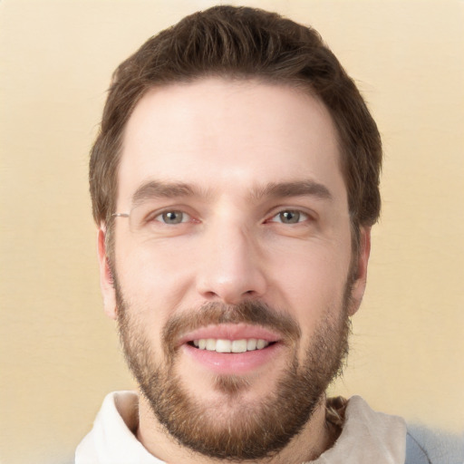 Joyful white young-adult male with short  brown hair and grey eyes