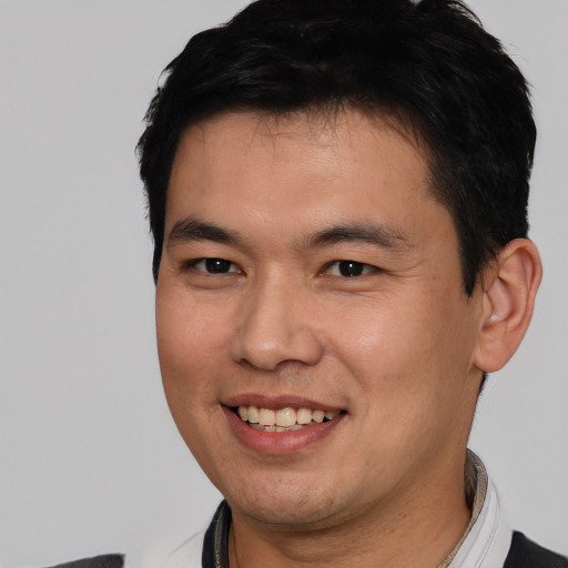 Joyful asian young-adult male with short  brown hair and brown eyes