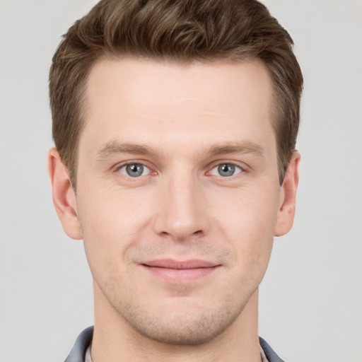 Joyful white young-adult male with short  brown hair and grey eyes