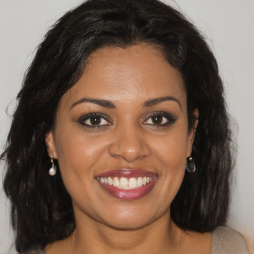 Joyful black young-adult female with long  brown hair and brown eyes
