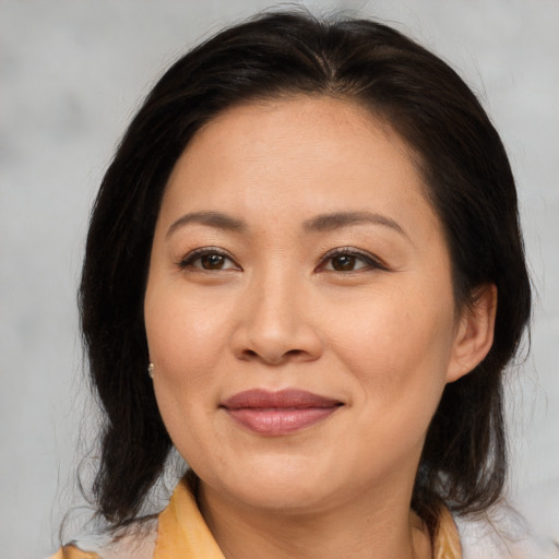 Joyful asian adult female with medium  brown hair and brown eyes