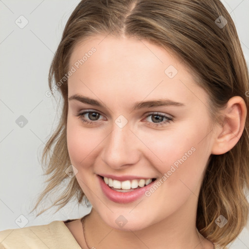 Joyful white young-adult female with medium  brown hair and grey eyes