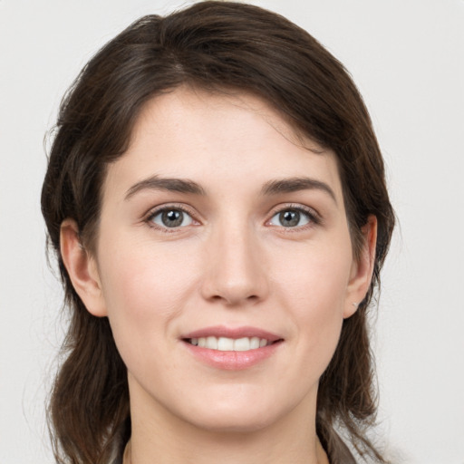 Joyful white young-adult female with medium  brown hair and grey eyes