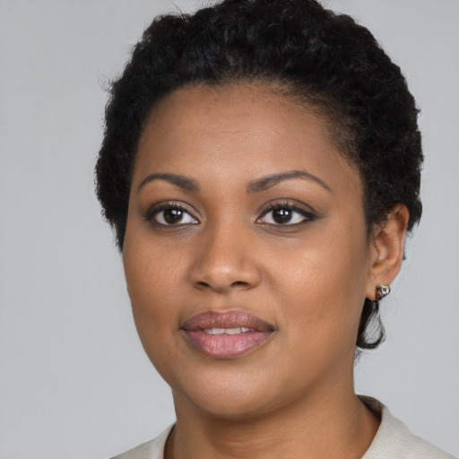 Joyful black young-adult female with short  black hair and brown eyes
