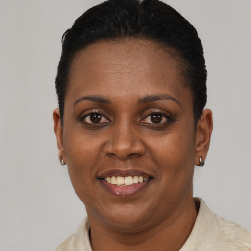 Joyful black young-adult female with short  black hair and brown eyes