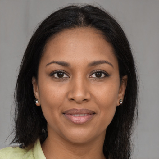 Joyful black young-adult female with long  brown hair and brown eyes