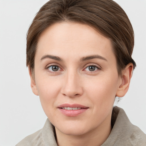 Joyful white young-adult female with short  brown hair and grey eyes