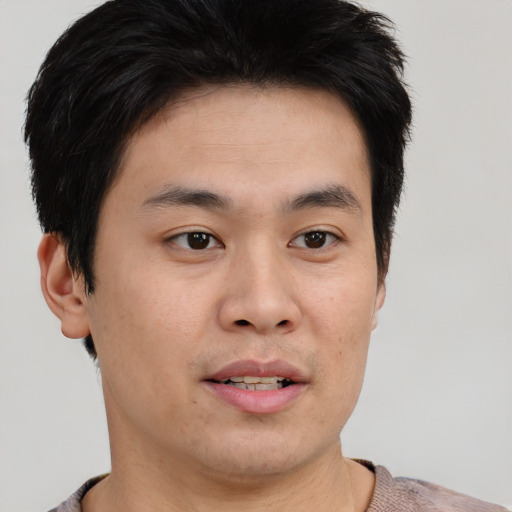 Joyful asian young-adult male with short  brown hair and brown eyes