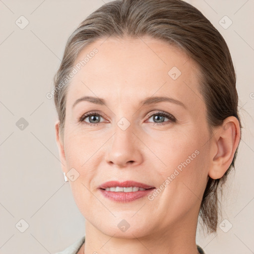 Joyful white adult female with medium  brown hair and grey eyes