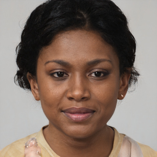 Joyful black young-adult female with short  black hair and brown eyes