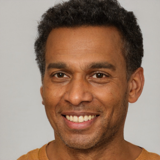Joyful latino adult male with short  brown hair and brown eyes