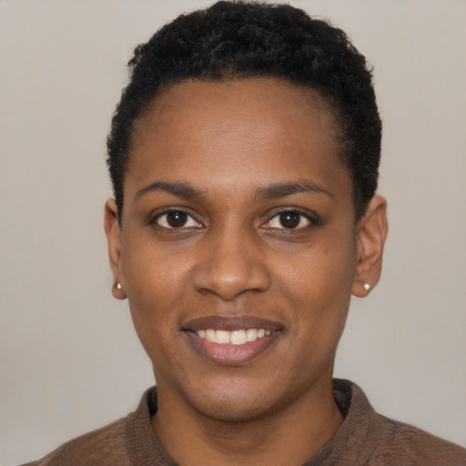 Joyful black young-adult female with short  black hair and brown eyes