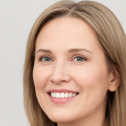 Joyful white adult female with long  brown hair and brown eyes