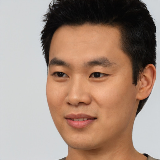 Joyful asian young-adult male with short  black hair and brown eyes